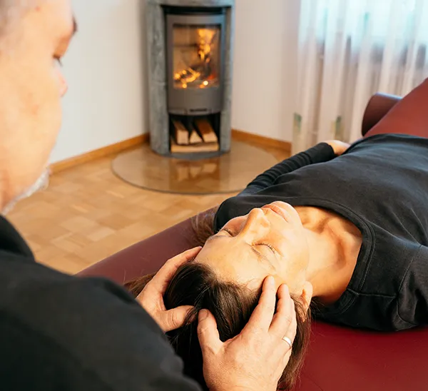 Rainer Weber wendet Cranio am Kopf einer Person an.